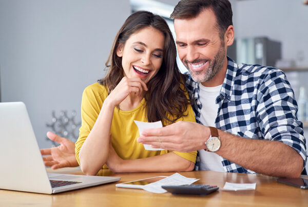 family smiling looking at the computer and receipt